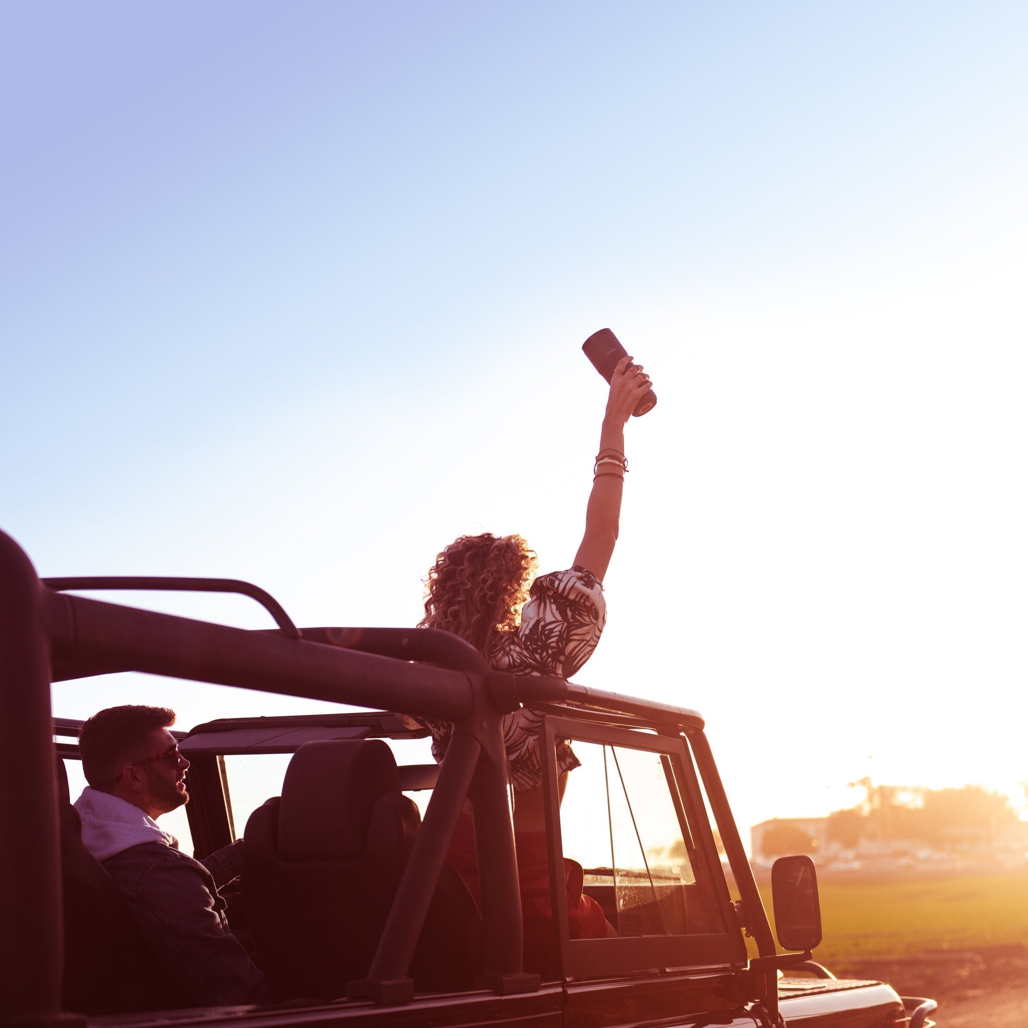 Car driving into the sun women holding the Ember Travel Mug 2+